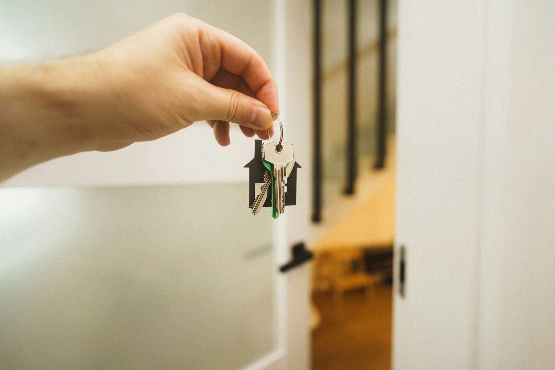 A hand holding a key up to a front door lock