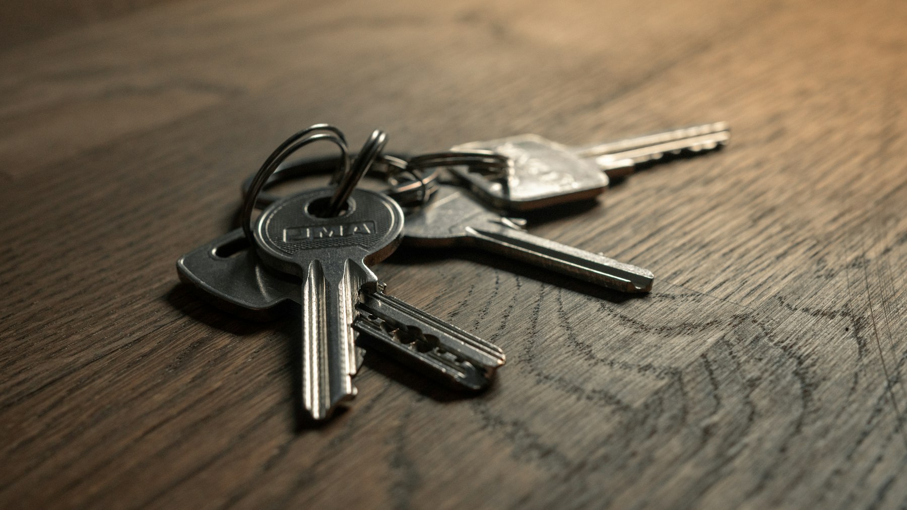 A bunch of keys on a wooden table